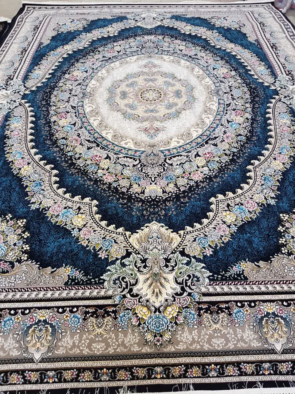 فرش ماشینی 700 شانه کاشان طرح ارمغان زمینه سرمه‌ای 10 رنگ